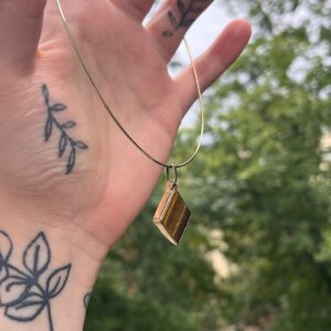 Nahaufnahme von Goldhalsreif mit Tigerauge Anhänger