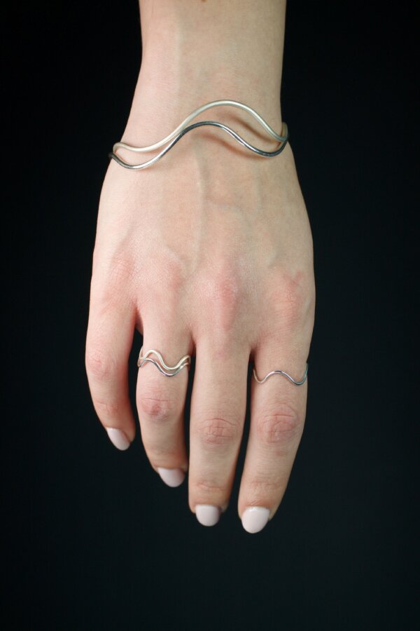 WAVI Ringe und Armreifen Nahaufnahme von geschwungenen Silberringen und Armreifen