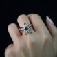 Nahaufnahme eines Rings aus 935 Silber mit geschwungenem Blumen-Design