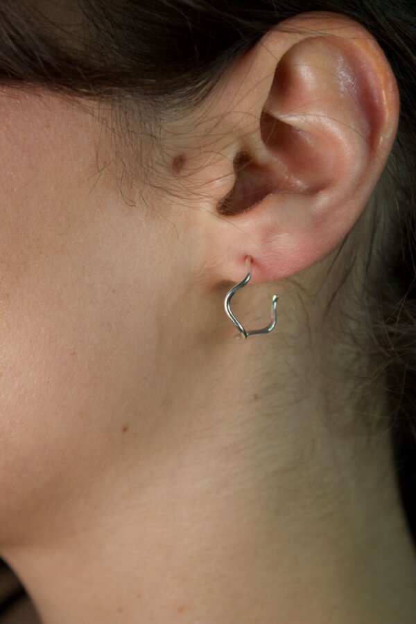 WAVI Ohrringe Nahaufnahme von geschwungenen Silberohrringen