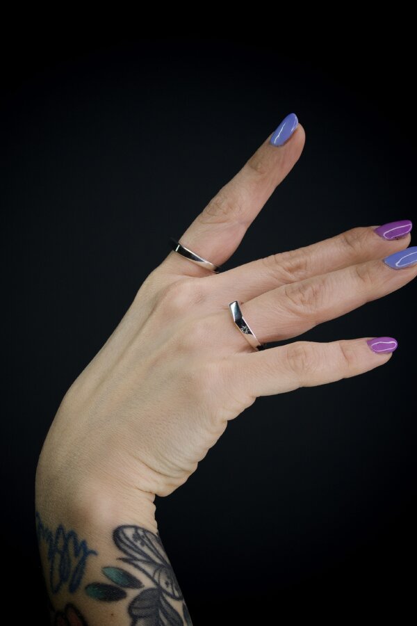 ADRIAN Ring Nahaufnahme von zwei Ringen aus Silber, Sternfassung mit grünem Zirkonia