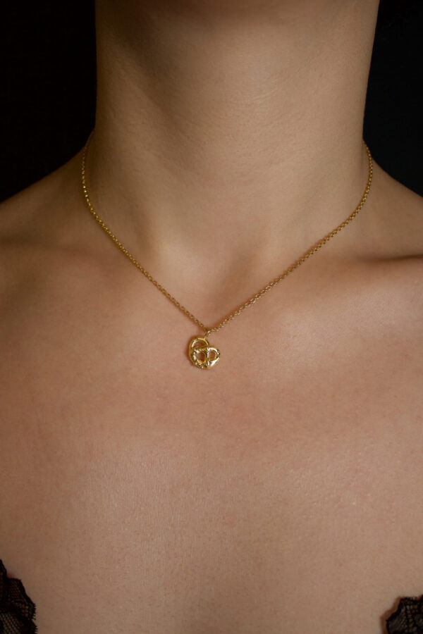 Anhänger Breznliebe gold Nahaufnahme einer Ankerkette mit Brezel-Anhänger aus Gold