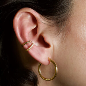Nahaufnahme von Earcuffs aus Gold in matt und glänzend