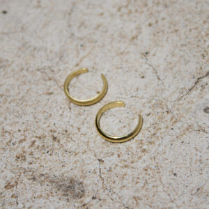 Nahaufnahme von Earcuffs aus Gold in matt und glänzend